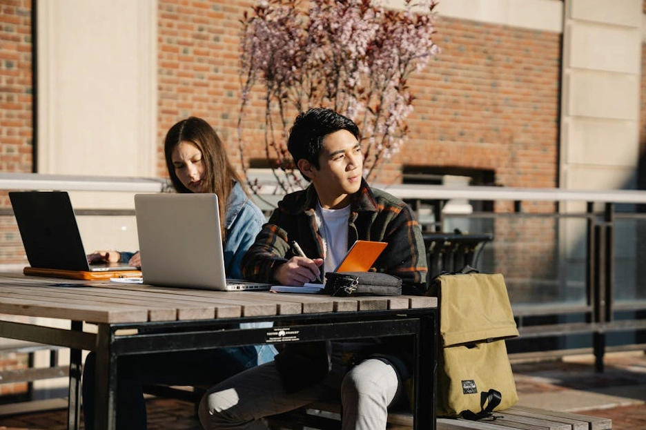 Studente sorridente con un laptop che partecipa a un corso online